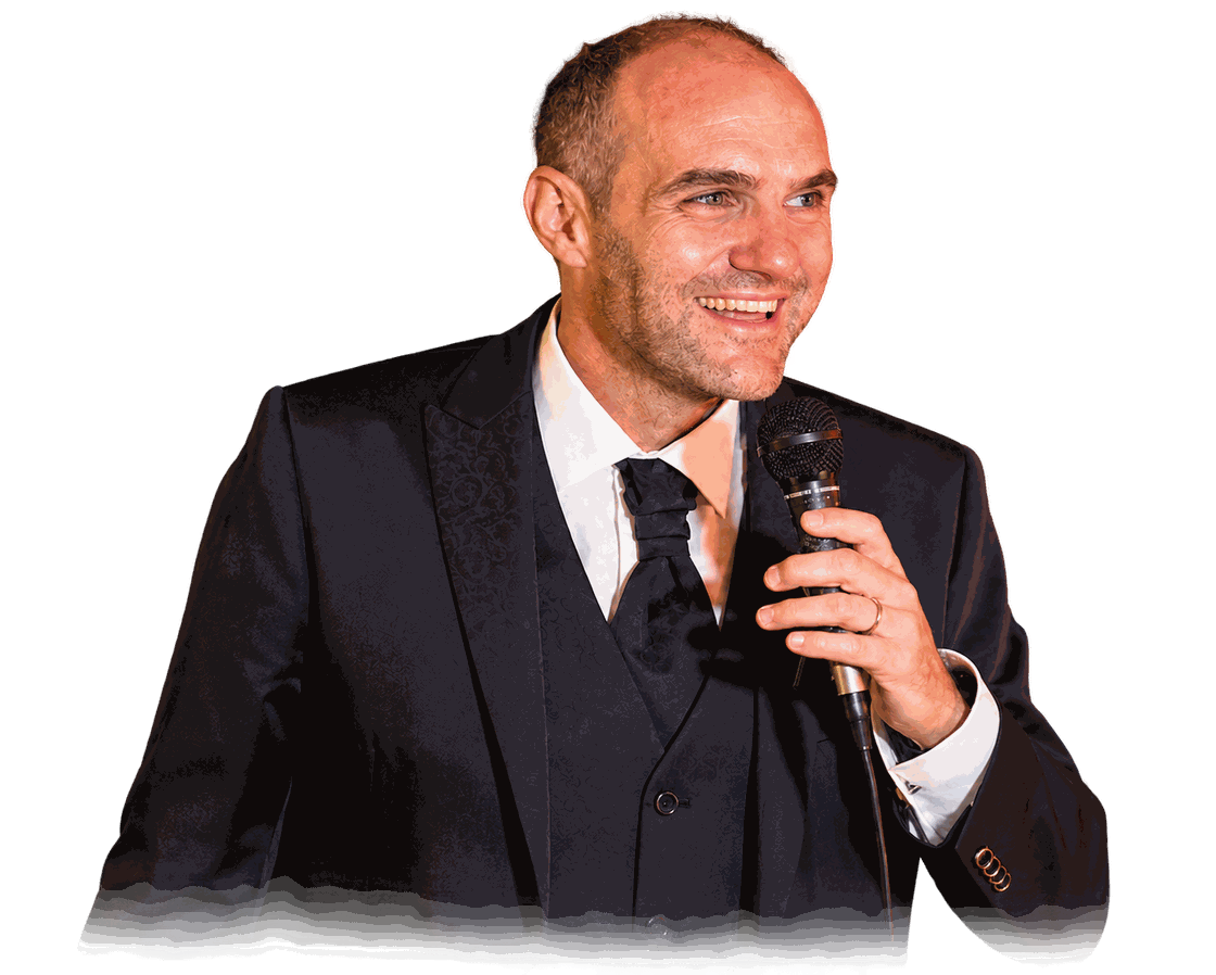 Claudio Faucci sorridente, in abito scuro, con un microfono in mano